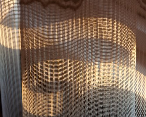 Living room with sheer curtains letting in soft natural sunlight