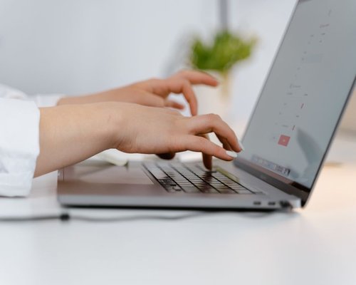 A person typing on a laptop with a correct ergonomic posture