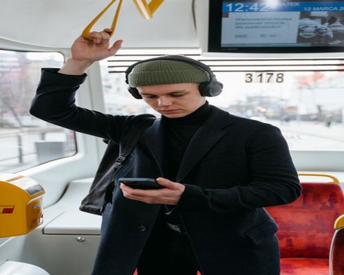 Commuter listening to music instead of looking at phone on a bus